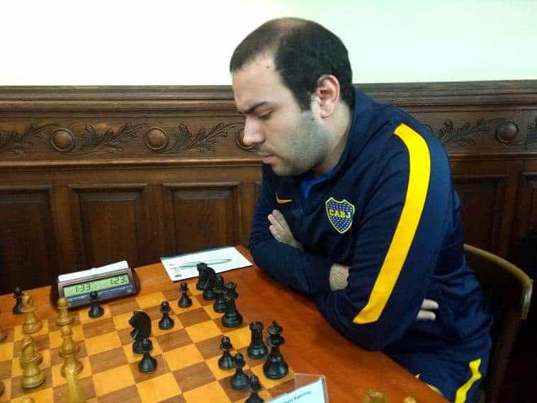 IM Kevin Paveto pensando frente al tablero de ajedrez